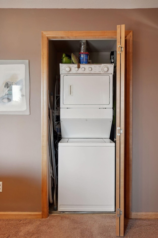 washroom featuring carpet flooring and stacked washer and dryer