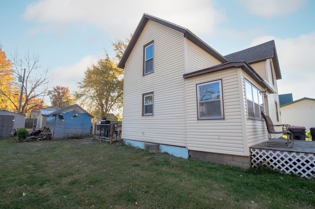 rear view of house with a shed and a lawn