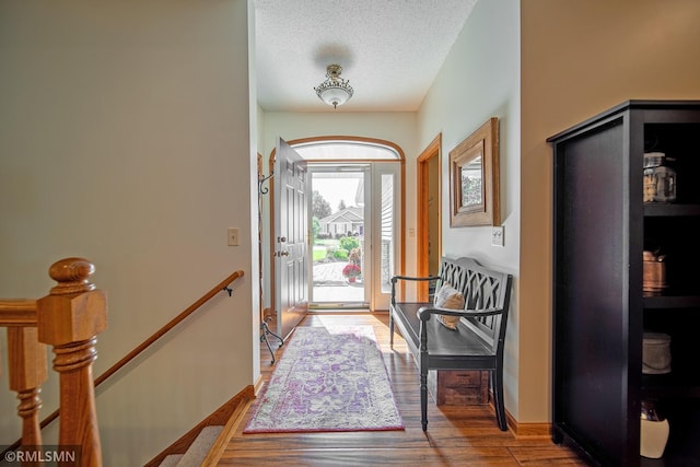 doorway featuring wood-type flooring and a textured ceiling