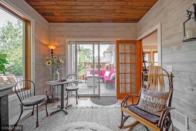 living area with hardwood / wood-style flooring and wooden walls