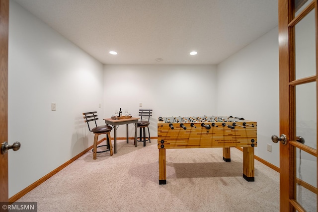 game room featuring carpet floors and a textured ceiling