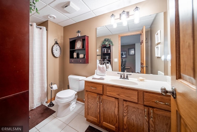 bathroom featuring vanity, toilet, a drop ceiling, a shower with curtain, and tile patterned flooring