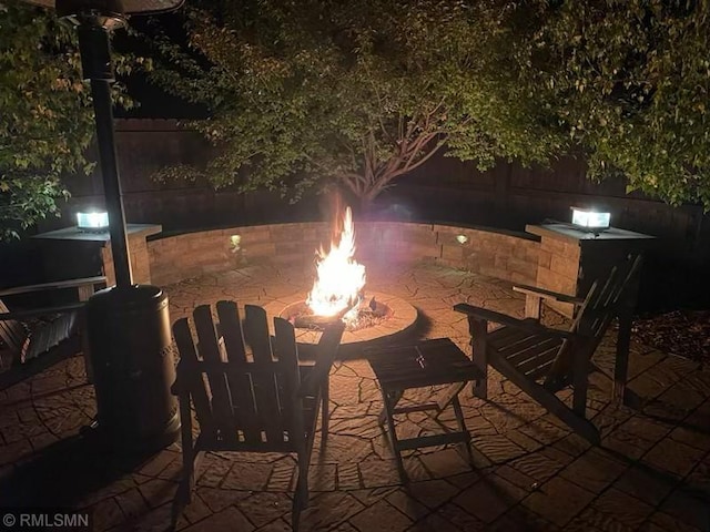 patio at night featuring a fire pit