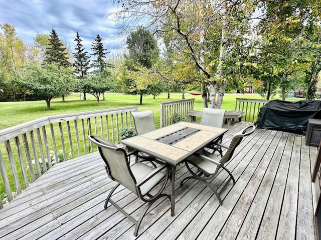312 Oakdale Ct NE, Warroad, MN 56763 - deck with outdoor dining area, a lawn, and view of scattered trees