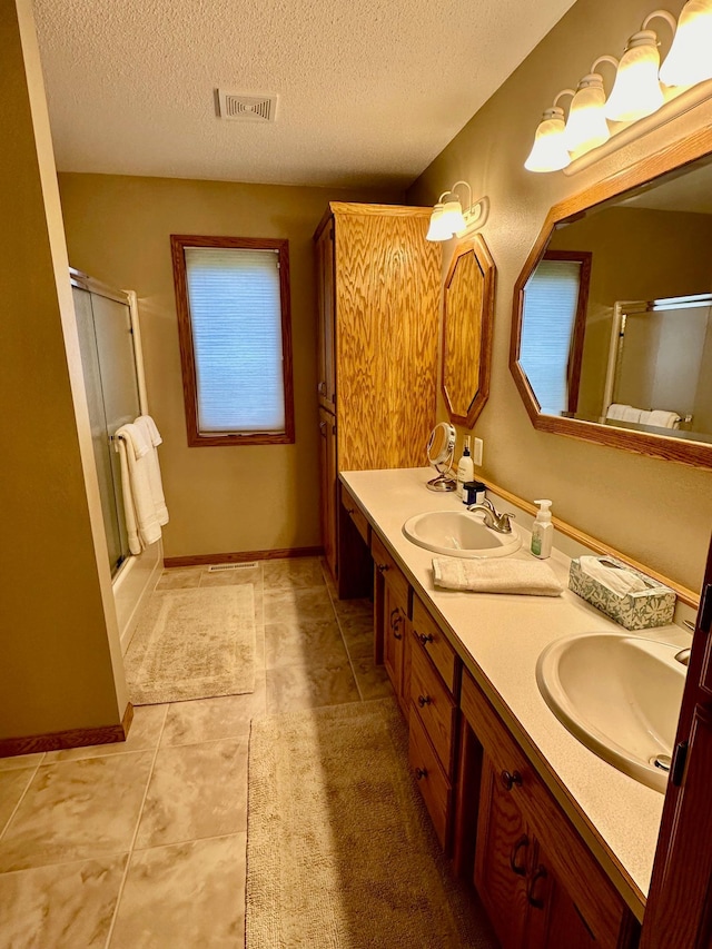 bathroom featuring tile patterned flooring, vanity, and a textured ceiling