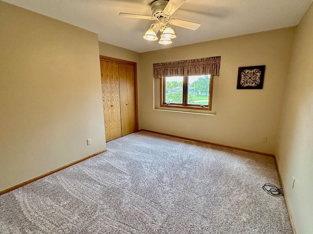 unfurnished bedroom with ceiling fan, light carpet, and a closet