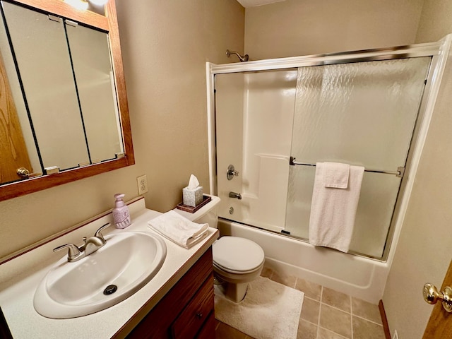 full bathroom featuring combined bath / shower with glass door, vanity, toilet, and tile patterned flooring