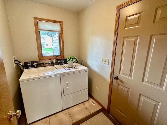 laundry area with independent washer and dryer and light tile patterned flooring