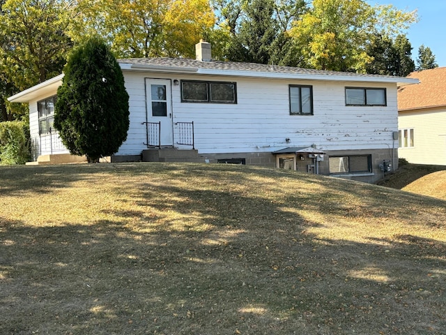 back of property featuring a lawn