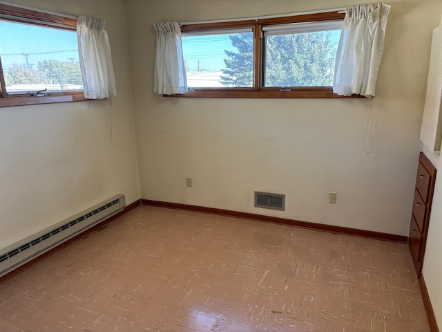 spare room with baseboard heating and a healthy amount of sunlight