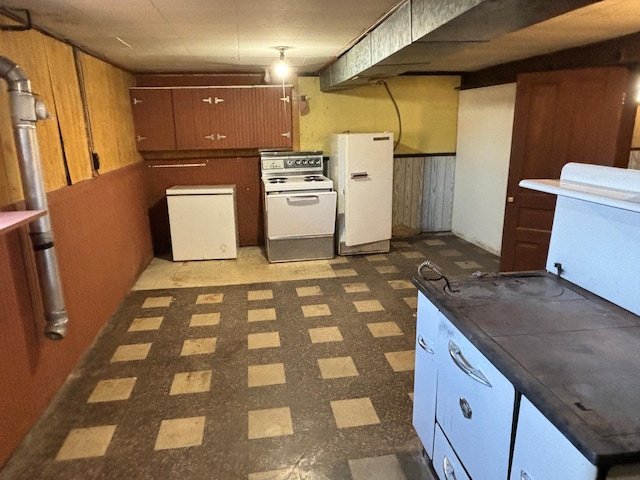 kitchen featuring wooden walls and white appliances