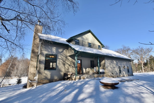 snow covered property with covered porch