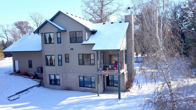 snow covered property with central AC unit