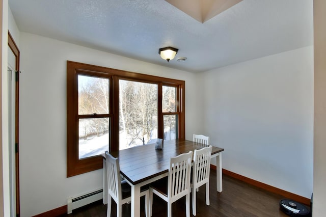 dining room featuring a baseboard heating unit and dark hardwood / wood-style floors