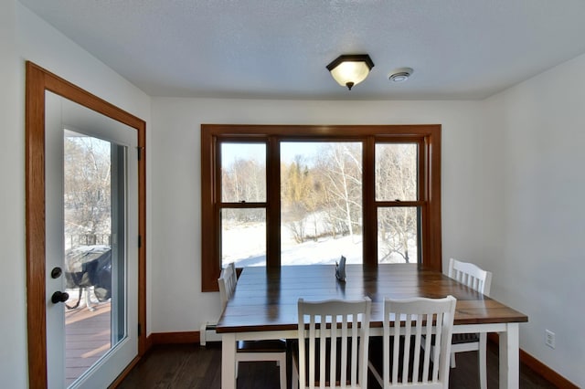 dining area featuring a textured ceiling, baseboard heating, and dark wood-type flooring