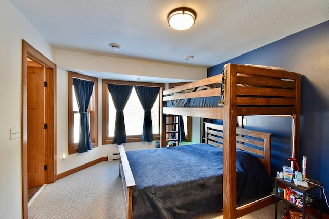 carpeted bedroom with a baseboard radiator and a textured ceiling