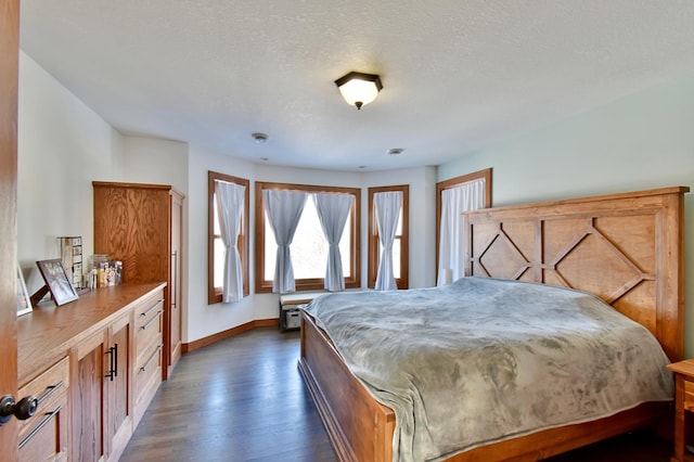 bedroom with a textured ceiling and dark hardwood / wood-style floors