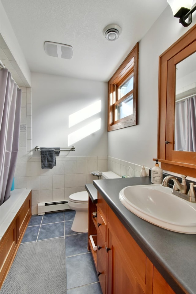 bathroom with toilet, tile walls, a baseboard heating unit, tile patterned floors, and vanity