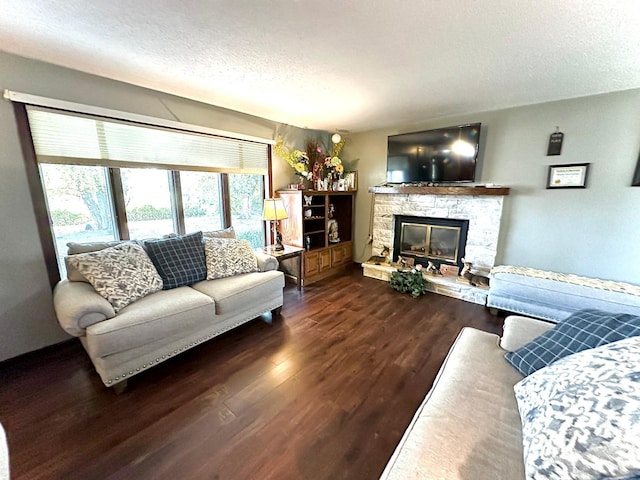 living room with a stone fireplace, a textured ceiling, and dark wood-type flooring