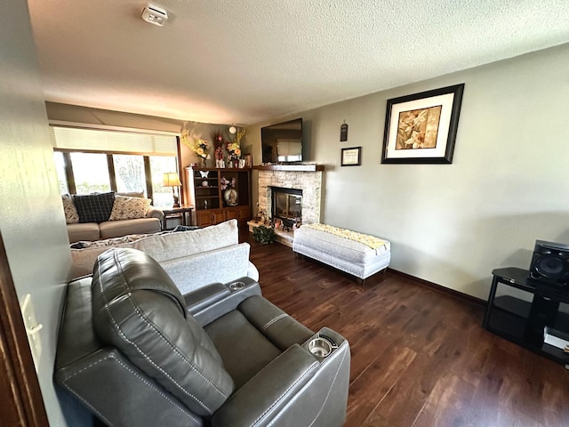 living room with a textured ceiling, a fireplace, and dark hardwood / wood-style flooring