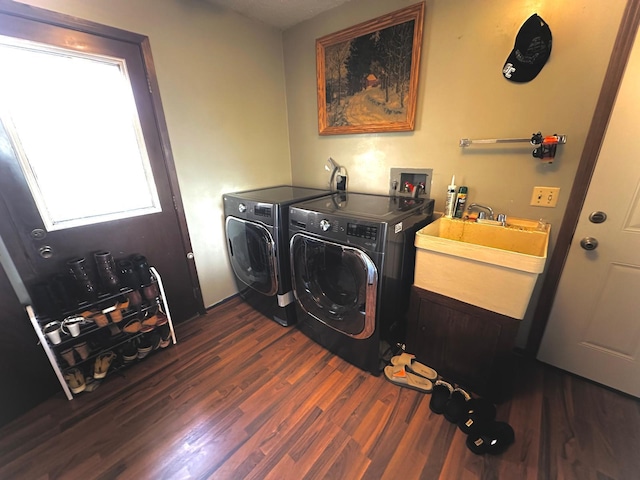 washroom with dark hardwood / wood-style floors, sink, and washer and clothes dryer