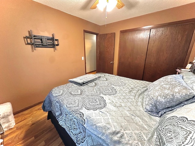 bedroom featuring hardwood / wood-style floors, ceiling fan, a closet, and a textured ceiling