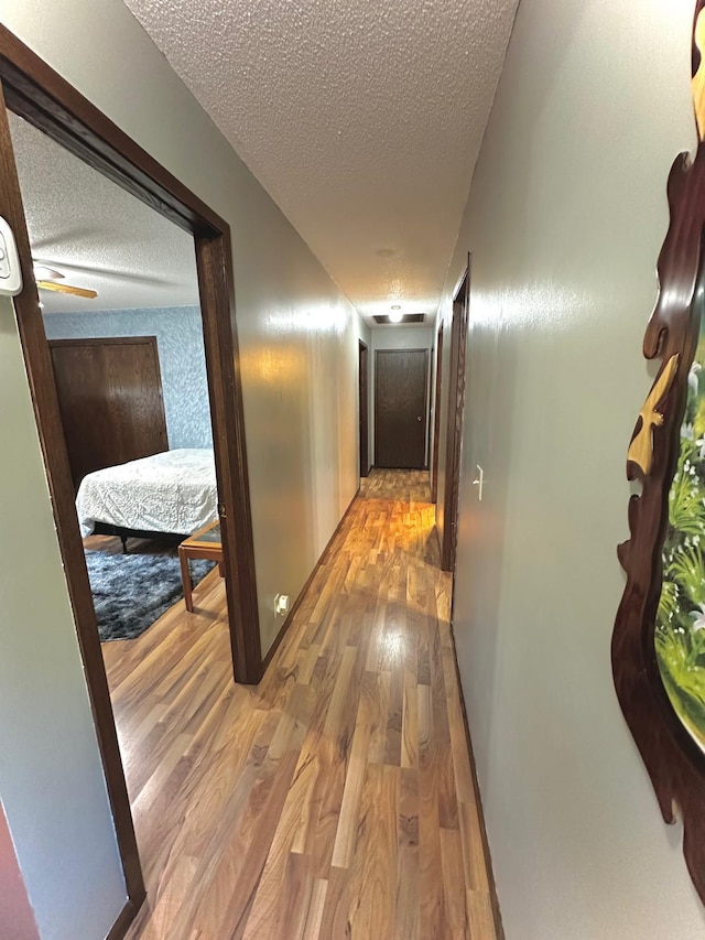 hallway featuring hardwood / wood-style floors and a textured ceiling