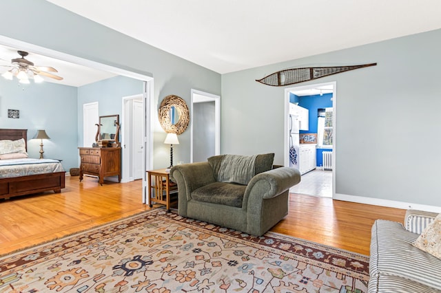 living room with hardwood / wood-style flooring, radiator heating unit, and ceiling fan