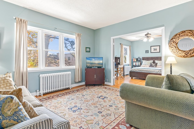 bedroom with ceiling fan, radiator heating unit, and a textured ceiling