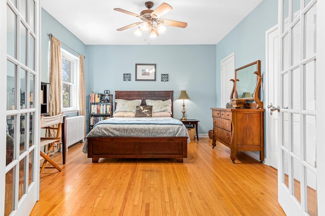 bedroom with ceiling fan, radiator, and light hardwood / wood-style flooring