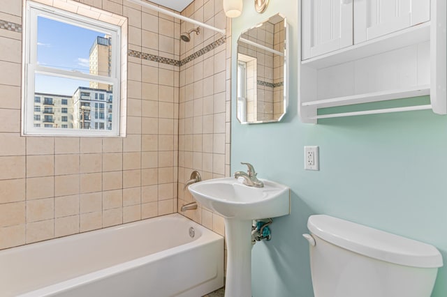 bathroom with toilet and tiled shower / bath combo