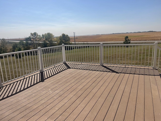 wooden terrace featuring a lawn and a rural view