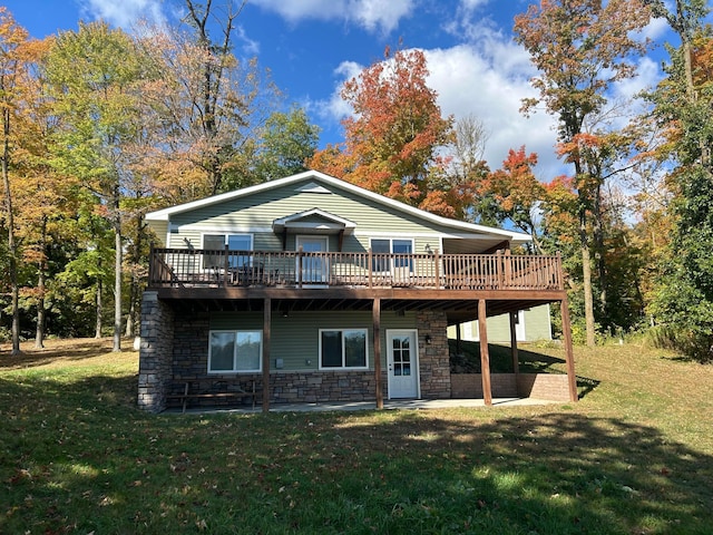 rear view of house featuring a lawn and a deck