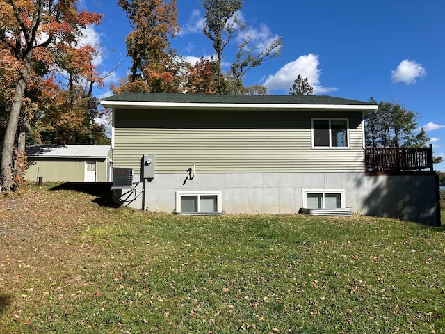 view of side of property featuring a deck and a yard