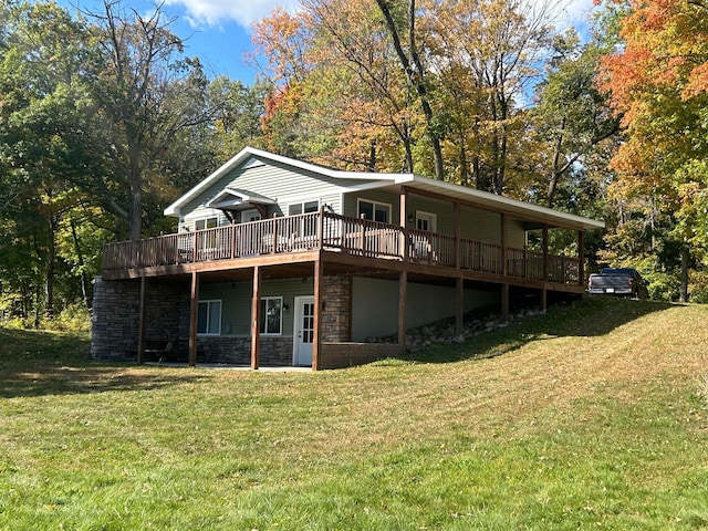 rear view of property featuring a wooden deck and a lawn