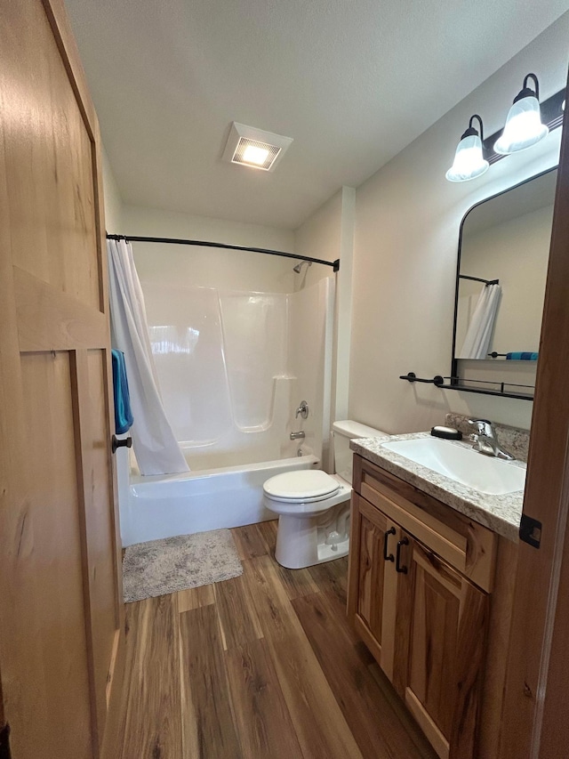 full bathroom with shower / bath combo with shower curtain, wood-type flooring, vanity, and toilet