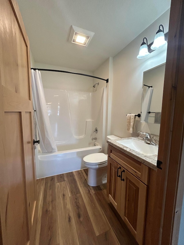 full bathroom with wood-type flooring, vanity, toilet, and shower / bath combo with shower curtain