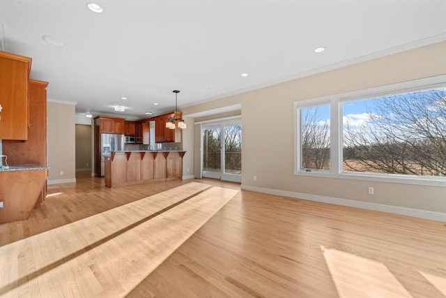 unfurnished living room with ornamental molding and light hardwood / wood-style floors