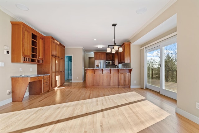 kitchen featuring hanging light fixtures, light hardwood / wood-style floors, kitchen peninsula, stainless steel appliances, and crown molding