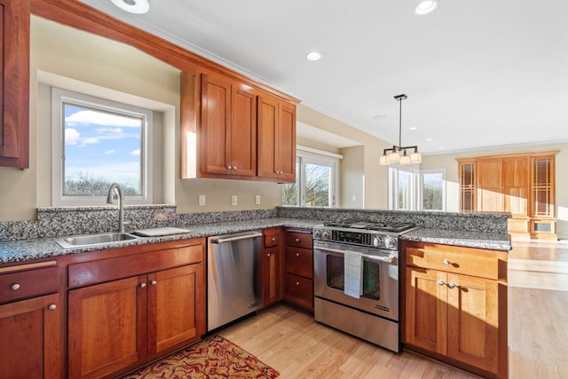 kitchen featuring sink, appliances with stainless steel finishes, hanging light fixtures, ornamental molding, and light wood-type flooring