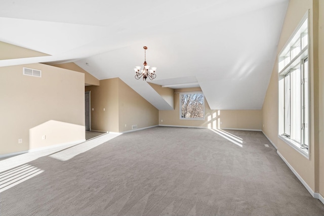 bonus room featuring lofted ceiling, light colored carpet, and a chandelier