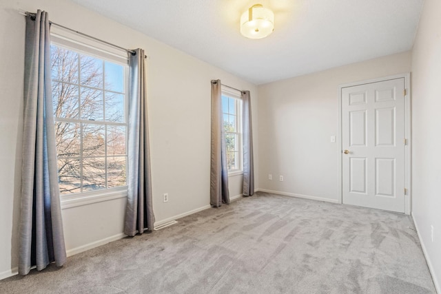 spare room with light carpet and a healthy amount of sunlight