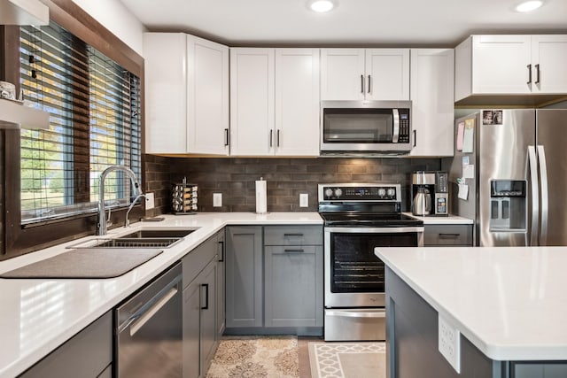 kitchen with white cabinets, sink, decorative backsplash, gray cabinets, and stainless steel appliances