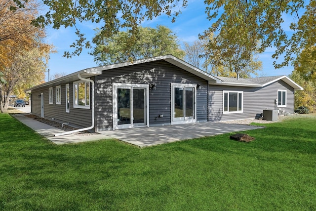 rear view of house with a yard, a patio, and central AC