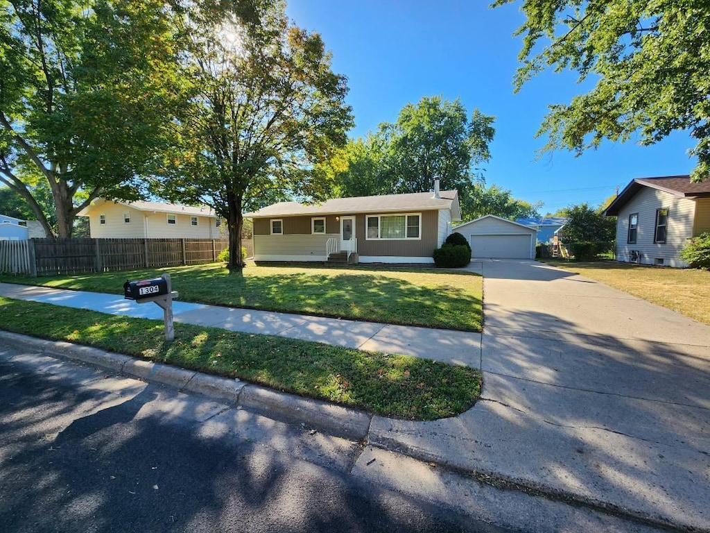 single story home with an outbuilding, a front yard, and a garage