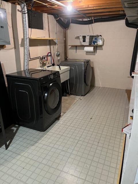 laundry room featuring washer and clothes dryer, sink, and electric panel