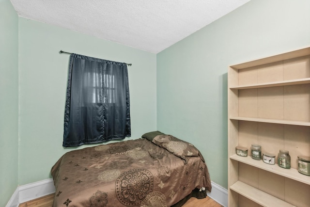 bedroom with light hardwood / wood-style floors and a textured ceiling