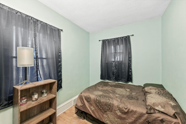 bedroom with wood-type flooring and a textured ceiling