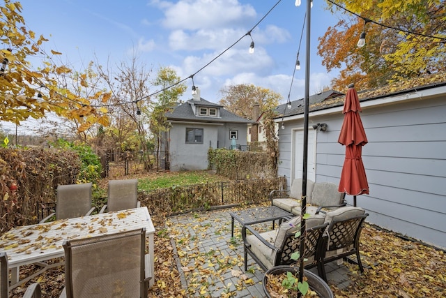 view of patio with an outbuilding, an outdoor hangout area, and fence