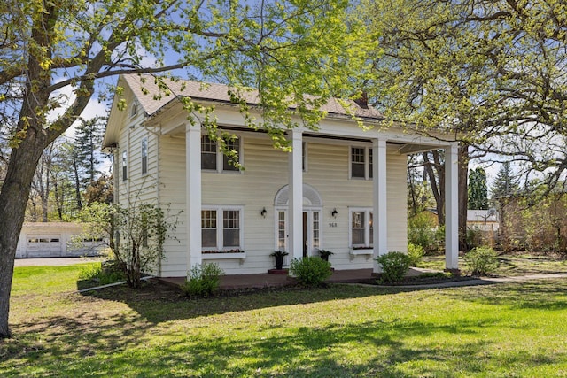 greek revival house with a front yard and roof with shingles